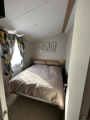 a bed in a small room with a window at Tattershall Lakes getaway in Tattershall