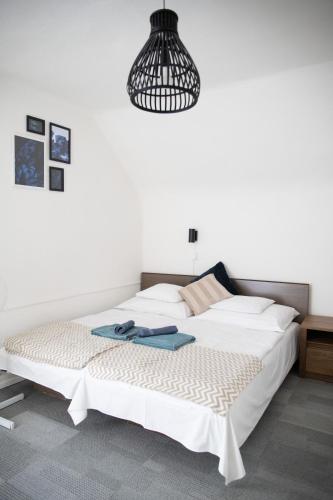 a bedroom with a large white bed and a black light at Simply House in Balatonboglár