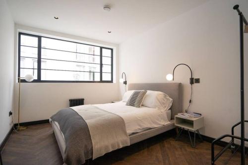Habitación blanca con cama y ventana en Chic City Centre Penthouse, en Leicester