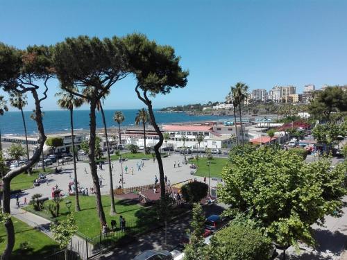 a park with palm trees and the ocean in the background at Vista Mare casa vacanze in Torre Annunziata