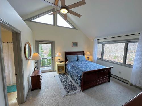 Schlafzimmer mit einem Bett und einem Deckenventilator in der Unterkunft RE90 Rare riverfront family retreat - private slopeside home with AC, fast WiFi, and views in Bretton Woods