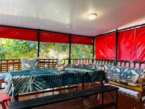 une véranda avec un lit et des canapés dans l'établissement moorea temae bungalow lory bord de mer, à Moorea