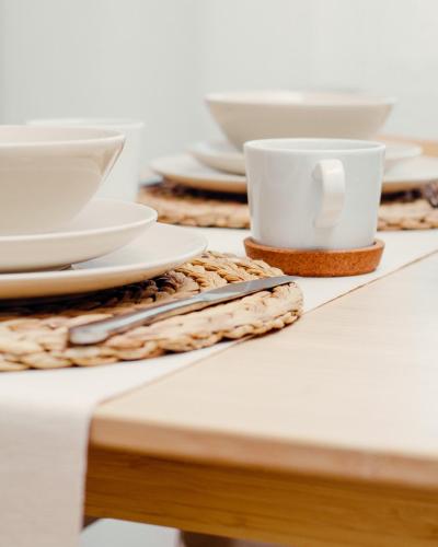 a table with plates and cups on top of it at Giewont Mountain View Apartment in Zakopane