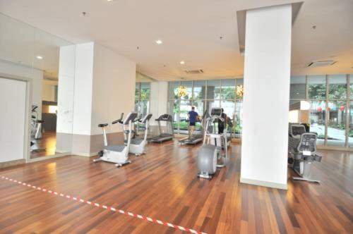 a gym with a wooden floor and cardio equipment at Maxhome@Regalia suite residence. KL in Kuala Lumpur