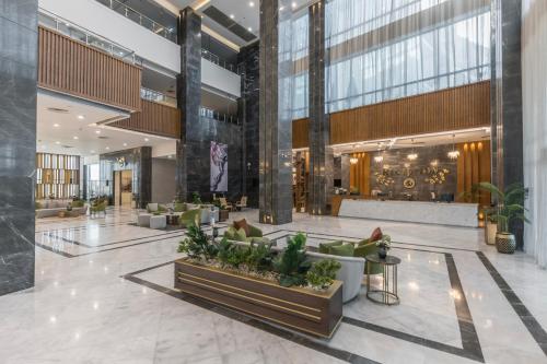a lobby of a building with couches and plants at Gewan White Beach Resort-New Alamein in Marsa Matruh