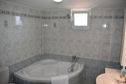 a bathroom with a bath tub and a sink at Arion Residence in Pigi