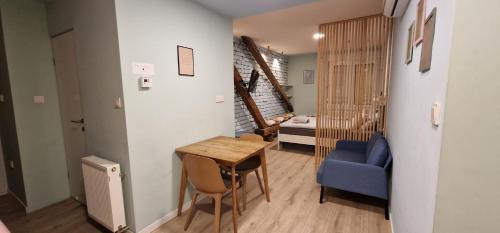 Mały pokój ze stołem i niebieskim krzesłem w obiekcie Rainbow Central Studio by Carpe Diem w Zagrzebiu