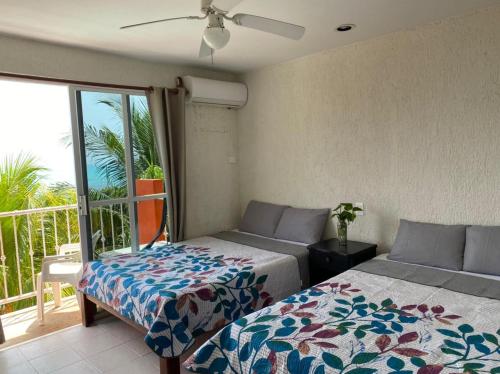 a bedroom with two beds and a balcony at Hotel Ma Elena in Isla Mujeres