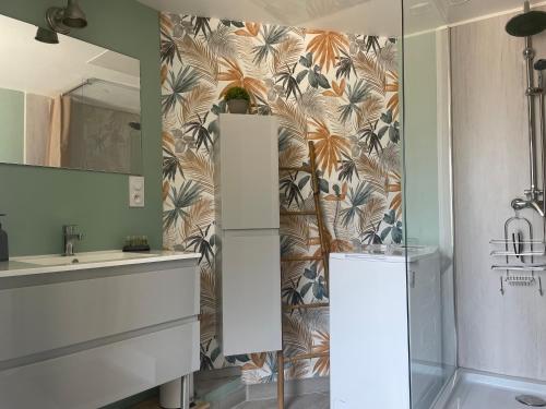 W łazience znajduje się umywalka i lustro. w obiekcie L'Abeille SAS le jardin de Messie w mieście Beaumont
