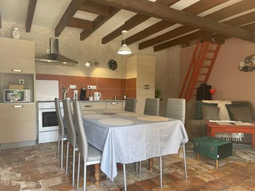 eine Küche und ein Esszimmer mit einem Tisch und Stühlen in der Unterkunft L'Abeille SAS le jardin de Messie in Beaumont