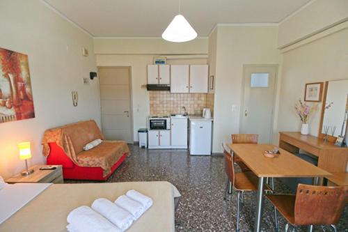 a living room with a couch a table and a kitchen at Selana Apartments in Mytilini