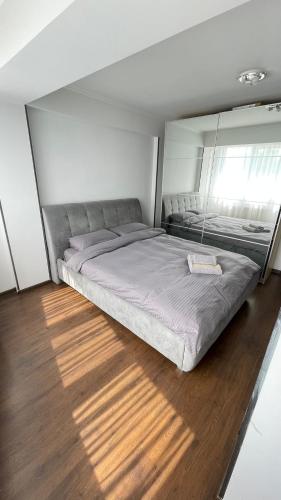 a large bed in a bedroom with a wooden floor at Home sweet home in Chişinău