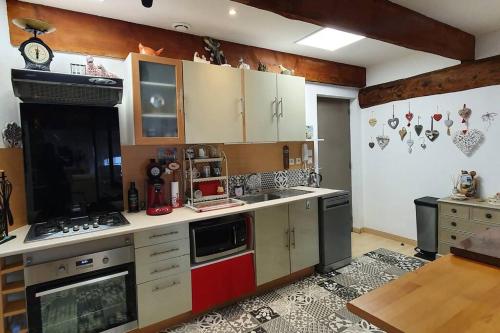 une cuisine avec des armoires blanches et un four à plaques de cuisson dans l'établissement Le Loft du 31 déco charme cosy centre Garage privé Climatisation, à Sète