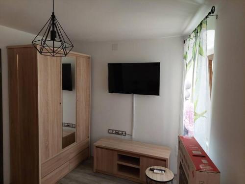 een woonkamer met een flatscreen-tv aan de muur bij Atraktivna kuca sa saunom i grijanim jacuzzijem in Cres