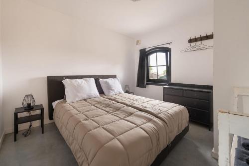 a bedroom with a large bed and a window at Vrijstaand huisje, dichtbij Kinderdijk in Oud-Alblas