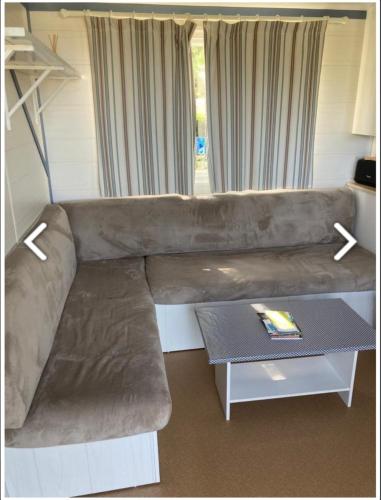 um sofá grande numa sala de estar com uma mesa em Mobile-home 4 pers vue mer em Saint-Cast-le-Guildo