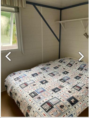 um quarto com uma cama com uma colcha em Mobile-home 4 pers vue mer em Saint-Cast-le-Guildo