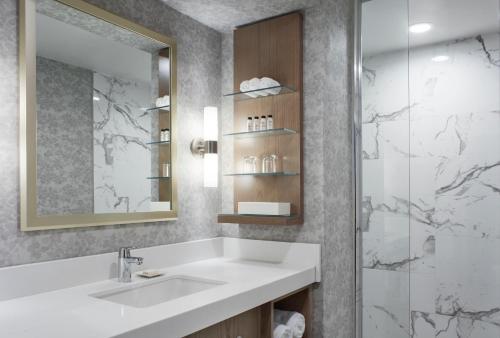 a bathroom with a sink and a shower at Delta Hotels by Marriott London Armouries in London