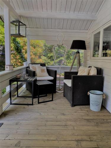 a porch with chairs and a table and a lamp at Les Rives des Habsbourg in Ensisheim