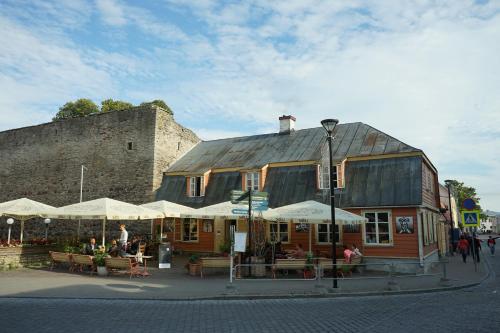 a building with tables and umbrellas in front of it at Karja Accommodation in Haapsalu