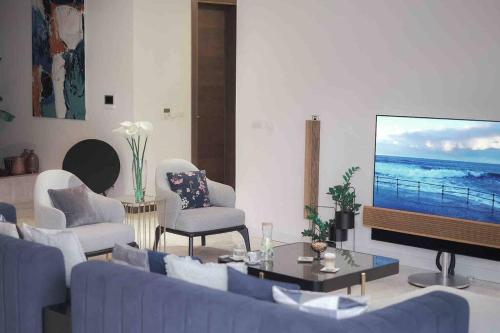 a living room with a blue couch and a tv at New luxury villa with 17m pool and bay view in Kotor