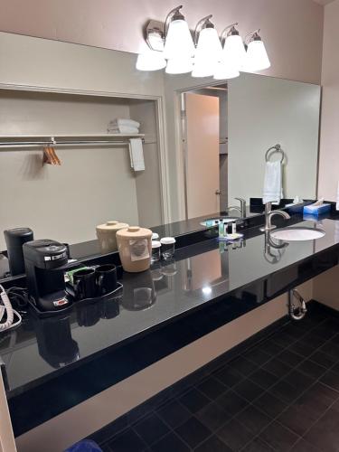 a bathroom counter with a sink and a mirror at Orange Tree Inn in Santa Barbara