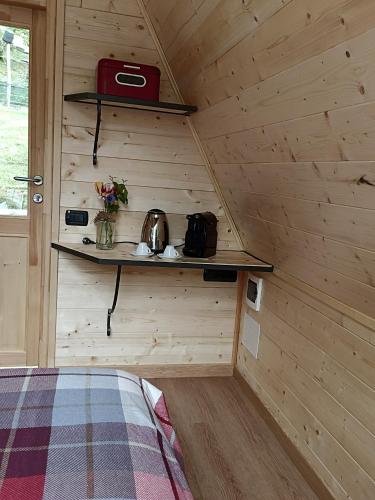 a small room with a bed in a wooden cabin at Baita Eleonora in Argegno