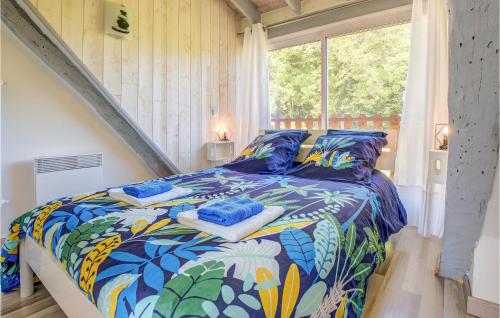 Un dormitorio con una cama con un edredón colorido y una ventana en Amazing Home In Blis Et Born With Kitchen, en Blis-et-Born