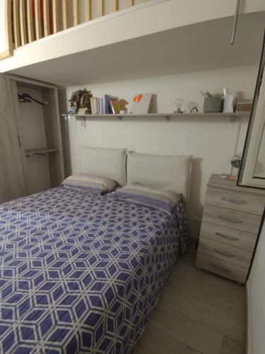 Dormitorio pequeño con cama y estante en Nina Apartment, en Mondragone