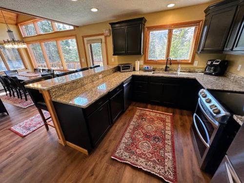 a kitchen with black cabinets and a counter top at New Property! Updated 3 bed 3 bath condo with mountain ski slope views in Bretton Woods in Bretton Woods