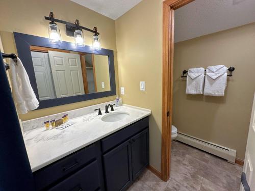 a bathroom with a sink and a mirror at New Property! Updated 3 bed 3 bath condo with mountain ski slope views in Bretton Woods in Bretton Woods