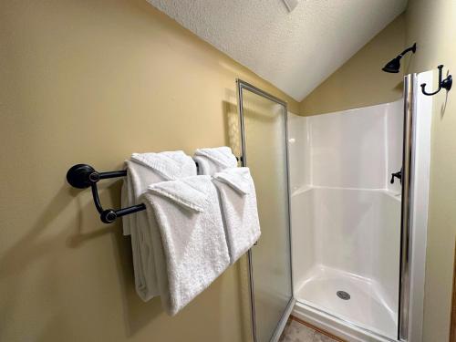 a bathroom with a shower and towels on a towel rack at New Property! Updated 3 bed 3 bath condo with mountain ski slope views in Bretton Woods in Bretton Woods