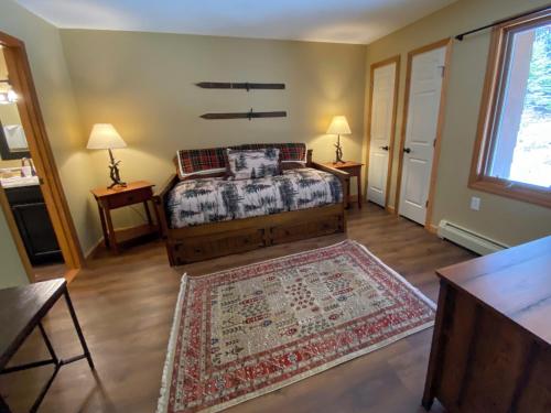 a bedroom with a bed and two tables and a window at New Property! Updated 3 bed 3 bath condo with mountain ski slope views in Bretton Woods in Bretton Woods