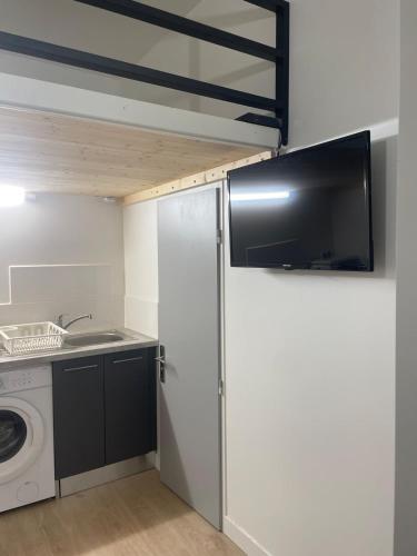 een keuken met een koelkast en een wasmachine bij Le petit Louis Fort - Studio cosy-Gratte Ciel in Villeurbanne
