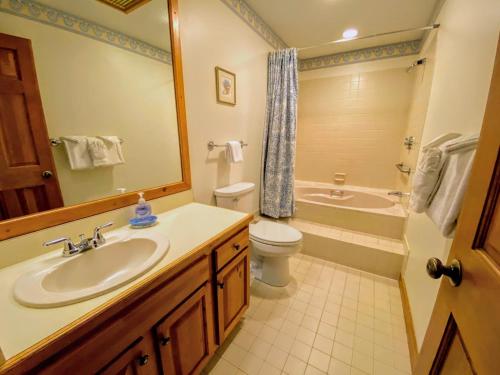 a bathroom with a sink and a toilet and a tub at FC20 Comfortable Forest Cottage home - AC, great for kids, lots of yard space! Walk to the slopes! in Bretton Woods