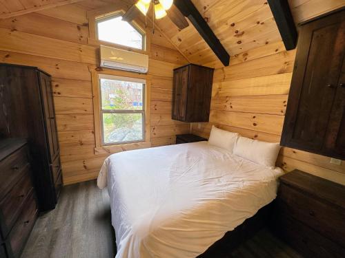 1 dormitorio con 1 cama en una cabaña de madera en BMV8 Tiny Home village near Bretton Woods en Twin Mountain