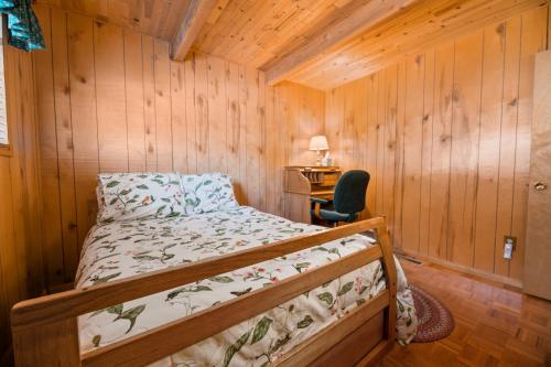 1 dormitorio con 1 cama en una cabaña de madera en Gnome Chalet - Charming Big Bear country home! Amazing craftsmanship and with a Fenced Yard!, en Big Bear Lake