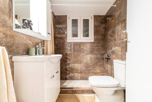 雅典的住宿－Modern African-inspired flat，浴室配有卫生间、盥洗盆和淋浴。