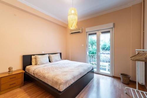 雅典的住宿－Modern African-inspired flat，一间卧室设有一张床和一个大窗户