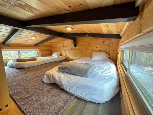 1 dormitorio con 2 camas en una cabaña de madera en BMV6 Tiny Home village near Bretton Woods en Twin Mountain