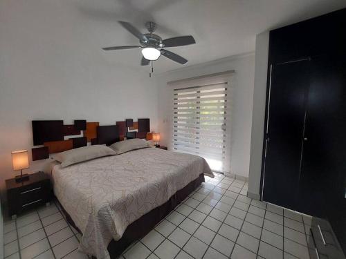 Un dormitorio con una cama y un ventilador de techo. en Villas Cozumel #4, en Cozumel
