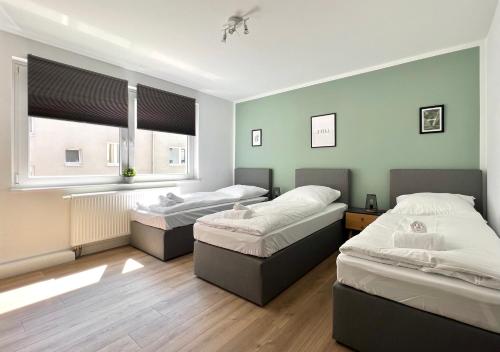een kamer met 3 bedden en een raam bij Sali - R4 - Apartmenthaus, WLAN, TV in Remscheid