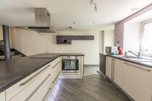 a kitchen with a sink and a counter top at Les Lilas - Confort - Calme - Wifi in Volvic
