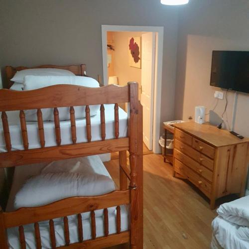 a bedroom with two bunk beds and a desk with a television at John Street Guest House in Kilkenny