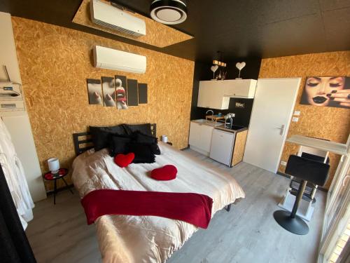 - une chambre avec un lit doté de deux coeurs rouges dans l'établissement Mini Love Room jacuzzi privatif, à Uriménil