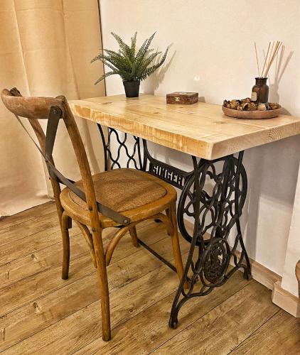 a wooden table with a chair next to a table with a bowl of fruit at U PASTURELLU in Pioggiola