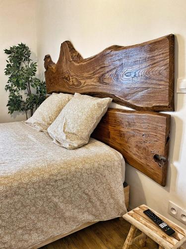 a bedroom with a wooden headboard and a bed at U PASTURELLU in Pioggiola