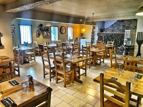 ein Restaurant mit Holztischen und Holzstühlen in der Unterkunft U PASTURELLU in Pioggiola