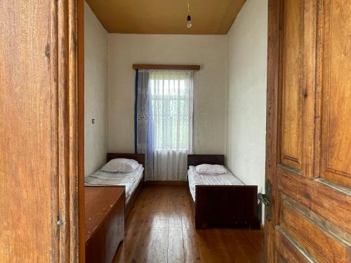 two beds in a small room with a window at Zaali's wine cellar in Vani