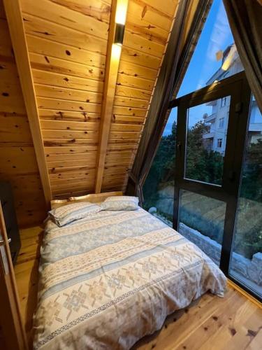 a bed in a room with a large window at Günışığı Bungalov in Rize